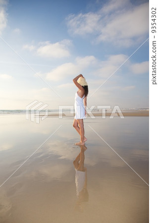 woman reflected on wet sand woman reflected on wet sand 9354302