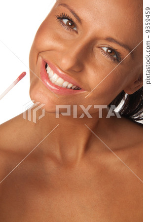 applying pink lip gloss 9359459