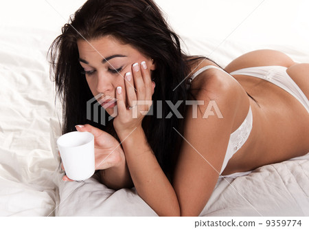 Pensive woman laying on bed 9359774