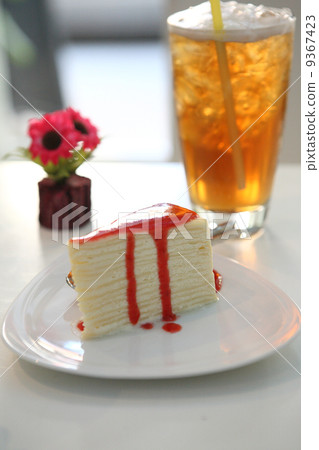 Crape cake pour with strawberry sauce on plate 9367423