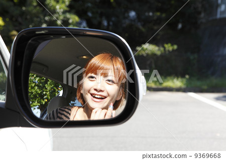 A woman making a make-up check with a side mirror A woman making a make-up check with a side mirror 9369668