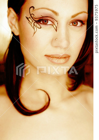 beauty portrait of a woman with ornaments around one eye 9375975
