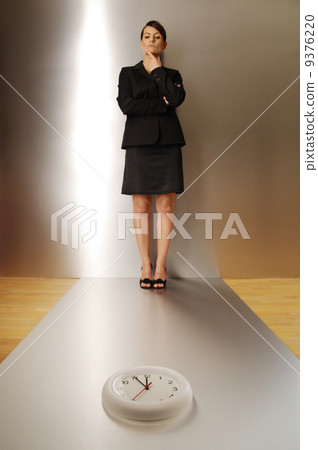 businesswoman looking at clock on floor focus on clock businesswoman looking at clock on floor focus on clock 9376220