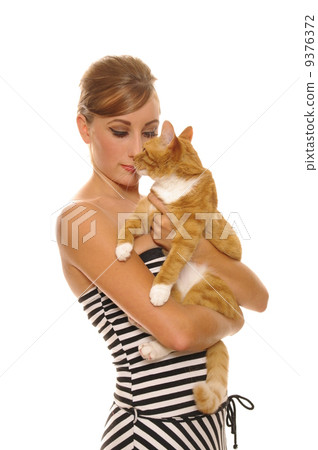 beautiful woman in black white striped dress holding cat 9376372