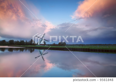 beautiful sunset over Dutch windmill by river 9381848
