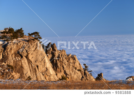 Mountains at sunset and sea in clouds 9381888