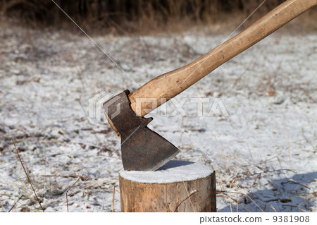 Axe and log in winter forest 9381908