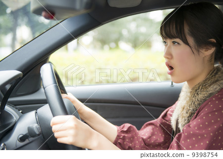 一個女人生氣時駕駛一輛車 9398754