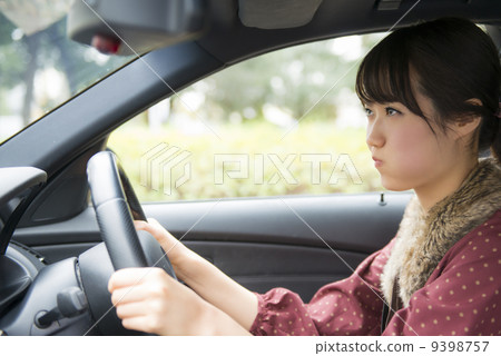 一個女人生氣時駕駛一輛車 9398757