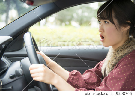 一個女人生氣時駕駛一輛車 9398766