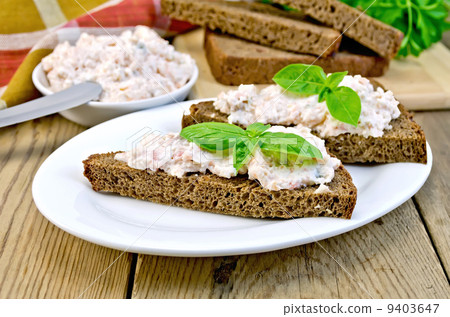 Sandwiches with cream of salmon and mayonnaise on the board 9403647