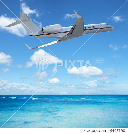 Private jet plane over the tropical sea 9407190