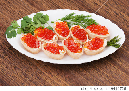 Tartlets with red caviar on wooden background. 9414726