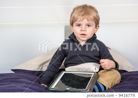 Little toddler boy playing with tablet pc 9416779