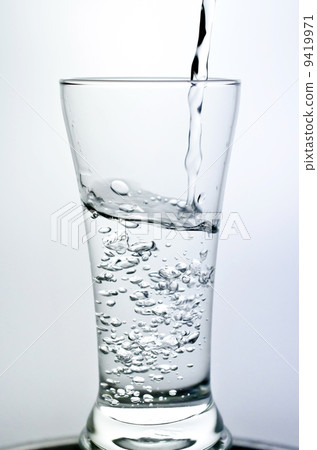 Filling a glass with water showing a drink concept 9419971