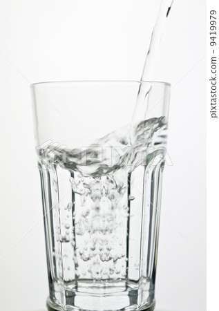 Filling a glass with water showing a drink concept Filling a glass with water showing a drink concept 9419979