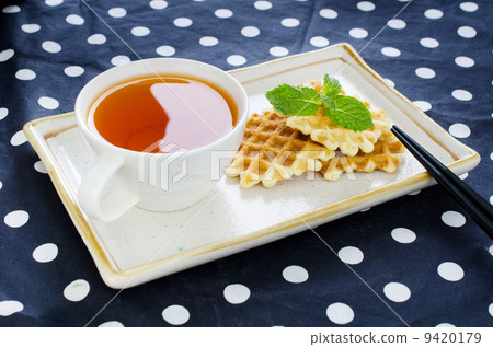 Tea with waffle and chopsticks in ceramic plate Tea with waffle and chopsticks in ceramic plate 9420179