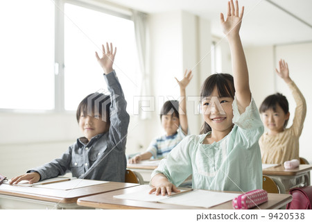 Elementary school student waving hands in the classroom 9420538