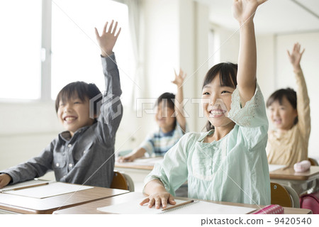 Elementary school student waving hands in the classroom 9420540