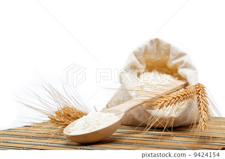 Flour and wheat grain with wooden spoon on a wooden table. Flour and wheat grain with wooden spoon on a wooden table. 9424154