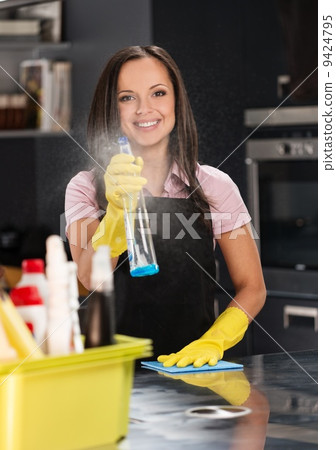 Beautiful cheerful brunette woman in gloves cleaning modern kitchen Beautiful cheerful brunette woman in gloves cleaning modern kitchen 9424795
