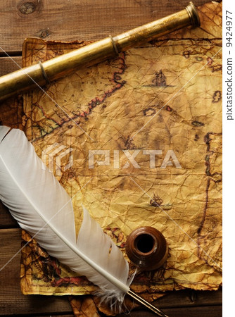 Spyglass and quill pen on old map over wooden background 9424977