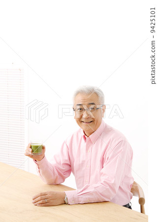 Senior man drinking green juice 9425101