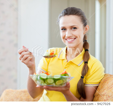 Happy girl eating veggie salad 9427026