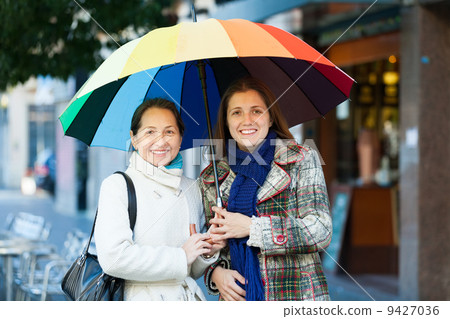 two happy women with umbrella 9427036