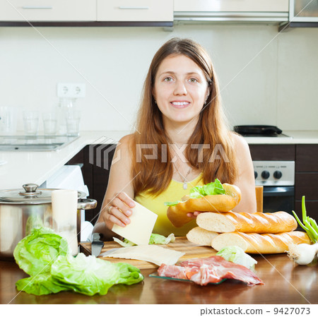 Happy woman cooking sandwiches 9427073