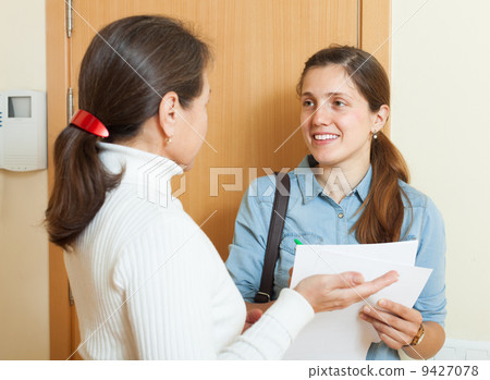 mature woman answer questions of woman with papers 9427078