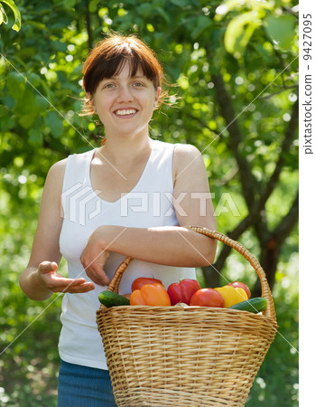 Happy woman with vegetables in garden 9427095