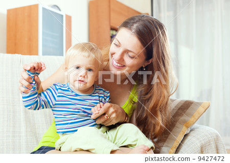 long-haired mother with toddler on sofa 9427472