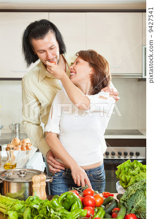 A man and a beautiful woman with vegetables in the kitchen 9427541