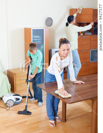 Parents with son dusting together Parents with son dusting together 9427577