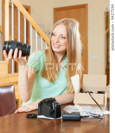 young girl unpacking new digital camera in home interior young girl unpacking new digital camera in home interior 9427594