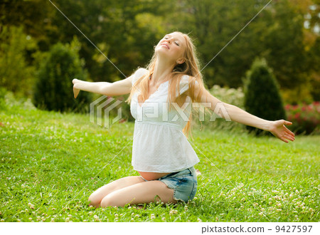 happy pregnant woman on the soft grass happy pregnant woman on the soft grass 9427597