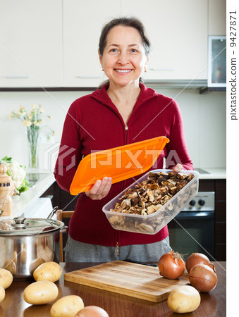 mature housewife with dried mushrooms 9427871