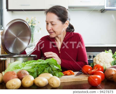 Mature woman in kitchen 9427873