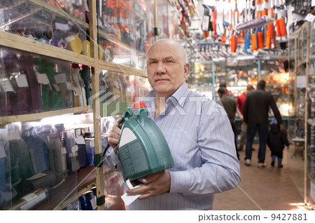 man holds motor oil in auto parts store 9427881