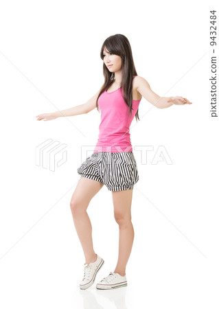 Young asian woman walking on imaginary rope Young asian woman walking on imaginary rope 9432484