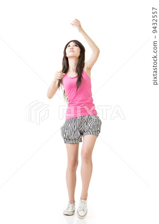 Young asian woman pulls an imaginary rope 9432557