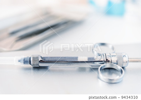 Empty dental syringe on steel surface 9434310