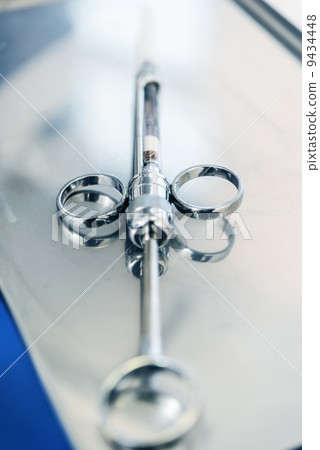 Empty dental syringe on steel surface 9434448
