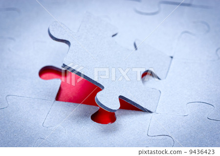 Piece of jigsaw revealing red background 9436423