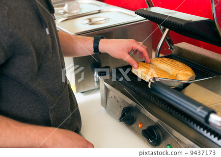 salesman making hotdog in fast food snack bar 9437173