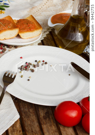 empty plate and bread  with tomatoes and olive oil 9442755