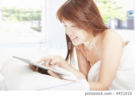 young woman using tablet on the bed 9451018