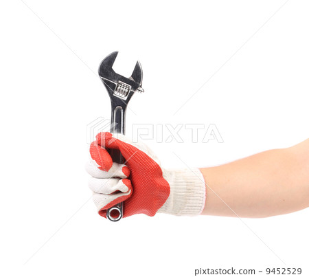 Hand in gloves holding wrench. 9452529