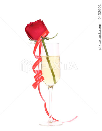 Rose in glass of champagne and streamer. 9452601